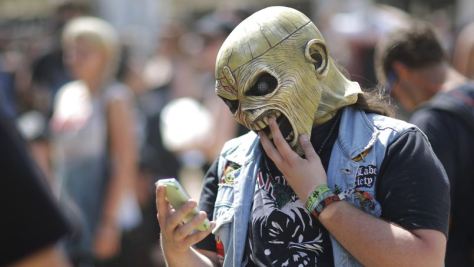 Festival-goer looks at his cellular phone during the Hellfest music Festival in Clisson