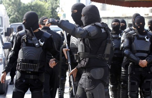 Riot police stand guard after Friday prayers near the al-Fatah mosque in Tunis