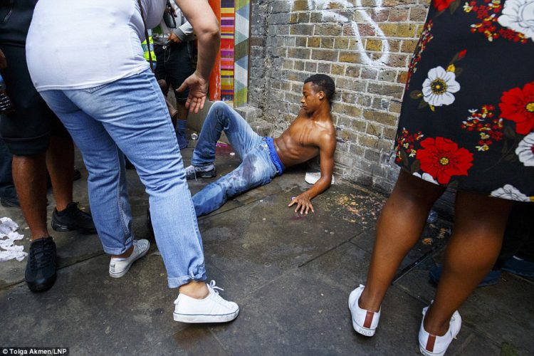 A man was helped by people on the street during the second day of the famous Notting Hill Carnival in West London