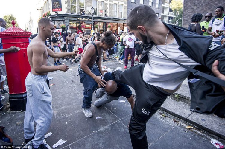 A fight broke out at the famous Notting Hill Carnival in West London and one man tried to kick another as he fell to the ground