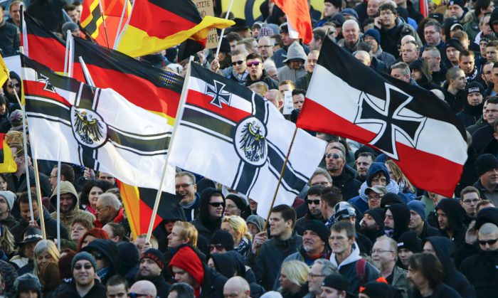Supporters of anti-immigration right-wing movement PEGIDA (Patriotic Europeans Against the Islamisation of the West) carry various versions of the Imperial War Flag (Reichskriegsflagge) during a demonstration march, in reaction to mass assaults on women on New Year's Eve, in Cologne, Germany January 9, 2016. Picture taken January 9, 2016. REUTERS/Wolfgang Rattay
