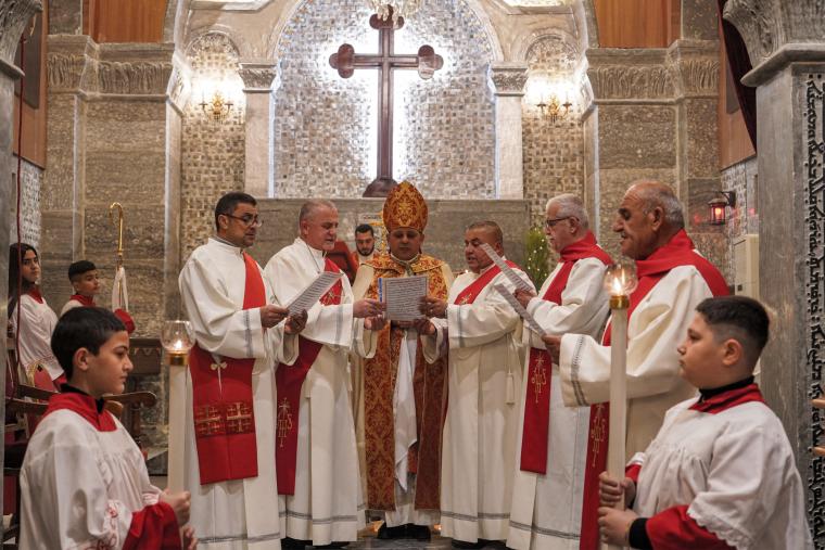 Ο πατέρας Thabet Habib Yousif al-Mekko (C), Χαλδαίος Επίσκοπος του Alqosh, ηγείται της λειτουργίας της παραμονής των Χριστουγέννων στη Χαλδαϊκή Καθολική Εκκλησία του Αγίου Γεωργίου στην πόλη Alqosh, 50 χιλιόμετρα βόρεια της βόρειας πόλης της Μοσούλης του Ιράκ στις 24 Δεκεμβρίου 2022