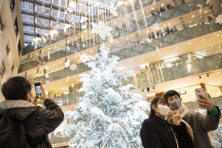 Ένα ζευγάρι βγάζει μια selfie με ένα χριστουγεννιάτικο δέντρο στο Τόκιο στις 25 Δεκεμβρίου 2022.