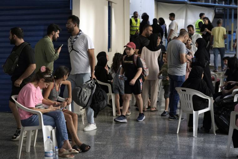 Άνθρωποι που φεύγουν από τις ισραηλινές αεροπορικές επιδρομές στο νότο, φτάνουν σε ένα σχολείο που έχει μετατραπεί σε καταφύγιο στη Βηρυτό