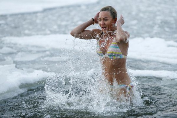 A woman takes dip in icy waters during celebrations for Orthodox Epiphany on Dnipro River in Kiev