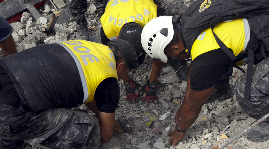 Police officers uncover the body of a victim after an earthquake struck off Ecuador's Pacific coast, at Tarqui neighborhood in Manta April 17, 2016. © Guillermo Granja