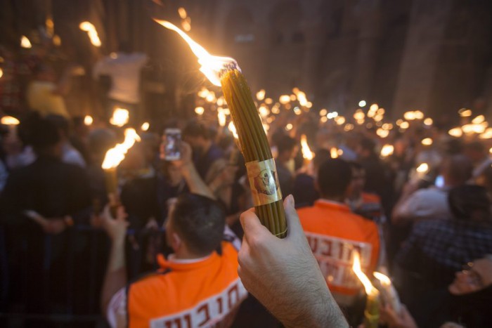 epa05284239 Orthodox Christian worshippers holding candles, 'lit from the Holy Fire,' at the Tomb of Christ as the miracle of the Holy Fire occurs in the Church of the Holy Sepulchre, Jerusalem, Israel, 30 April 2016. Eastern Orthodox Christians believe the Holy Fire, which emenates from within the Tomb of Christ and quickly spreads around the church and outside to Jerusalem and even to foreign countries, represents the flame of the Resurrection power, as well as the fire of the Burning Bush of Mount Sinai. EPA/ATEF SAFADI