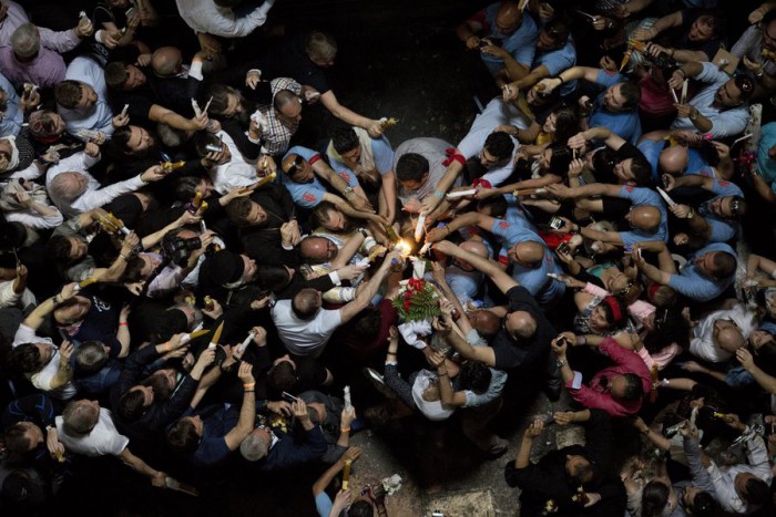 epa05284064 Orthodox Christian worshippers lighting candles at the Tomb of Christ as the miracle of the Holy Fire occurs in the Church of the Holy Sepulchre, Jerusalem, Israel, 30 April 2016. Eastern Orthodox Christians believe the Holy Fire, which emenates from within the Tomb of Christ and quickly spreads around the church and outside to Jerusalem and even to foreign countries, represents the flame of the Resurrection power, as well as the fire of the Burning Bush of Mount Sinai. EPA/ABIR SULTAN