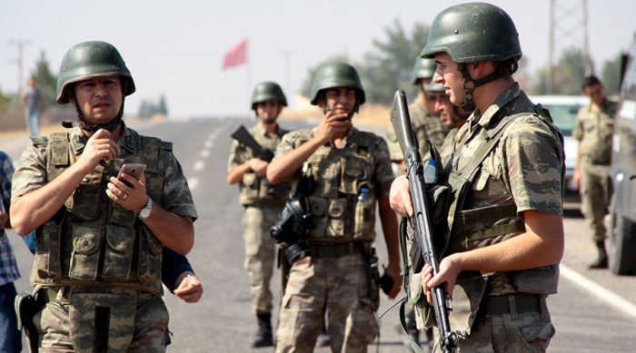 Turkish soldiers stand guard as a funeral convoy, carrying coffins of drowned Syrian migrants including the three-year old boy Aylan Kurdi, drives to the Turkish-Syrian border in Suruc, bordering with the northern Syrian town of Kobani, Turkey, September 4, 2015. Two Syrian toddlers who drowned with their mother as they were trying to reach Greece were laid to rest in the Syrian town of Kobani on Friday, a Reuters witness said. A photograph of the body of one of the toddlers, 3-year-old Aylan Kurdi, washed up on the shore, appeared in newspapers around the world this week, prompting sympathy and outrage at the perceived inaction of developed nations in helping refugees. REUTERS/Sertac Kayar - RTX1R28Z