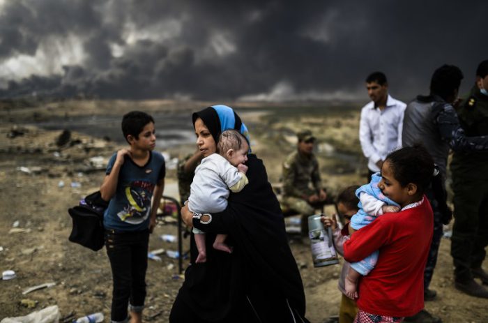 Iraqi families, who were displaced by the ongoing operation by Iraqi forces against jihadists of the Islamic State group to retake the city of Mosul, are seen gathering on an area near Qayyarah on October 24, 2016. / AFP PHOTO / BULENT KILIC