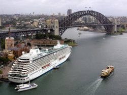 SYDNEY, AUSTRALIA: The cruise liner "Crystal Serenity" sits berthed at Sydney's historic Rocks area (L), 17 February 2005, with the Harbour Bridge (top). Australia's biggest sporting, entertainment and cultural festival, "Easter in Sydney", now in its second year and taking place over two weeks next month between 17 March and 03 April, is anticipated to bring in an extra 30,000 visitors to explore the city. AFP PHOTO/Greg WOOD (Photo credit should read GREG WOOD/AFP/Getty Images)