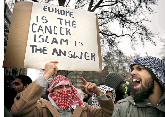 LONDON - FEBRUARY 03: Muslim demonstrators hold banners at the Danish Embassy on February 3, 2006 in London. British muslims have condemned newspaper cartoons which first appeared in a Danish newspaper, some of which depict the Prophet Mohammed wearing a turban shaped like a bomb. The cartoons have sparked worldwide protests. (Photo by Peter Macdiarmid/Getty Images)