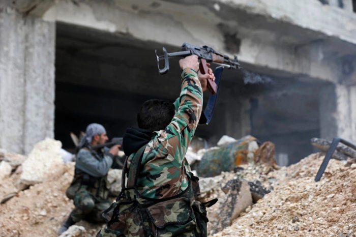 Syrian army soldiers fire their weapons during a battle with rebel fighters at the Ramouseh front line, east of Aleppo, Syria, Monday, Dec. 5, 2016. The government seized large swaths of the Aleppo enclave under rebel control since 2012 in the offensive that began last week. The fighting was most intense Monday near the dividing line between east and west Aleppo as government and allied troops push their way from the eastern flank, reaching within less than a kilometer (half a mile) from the citadel that anchors the center of the city. (AP Photo/Hassan Ammar)