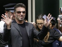 British musician George Michael gestures as he leaves Brent Magistrates Court in London June 8, 2007. Michael was banned from driving for two years and sentenced to 100 hours of community service on Friday after admitting driving when unfit. REUTERS/James Boardman (BRITAIN) - RTR1QLCW